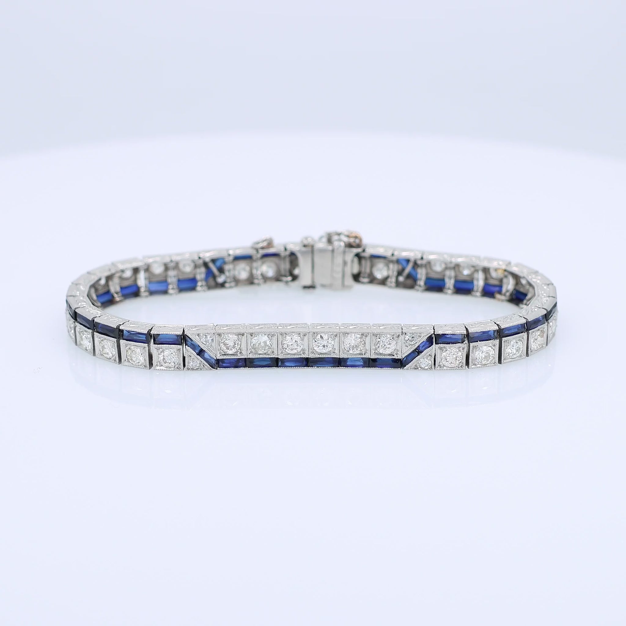 Platinum diamond bracelet with synthetic sapphire accents on a white background