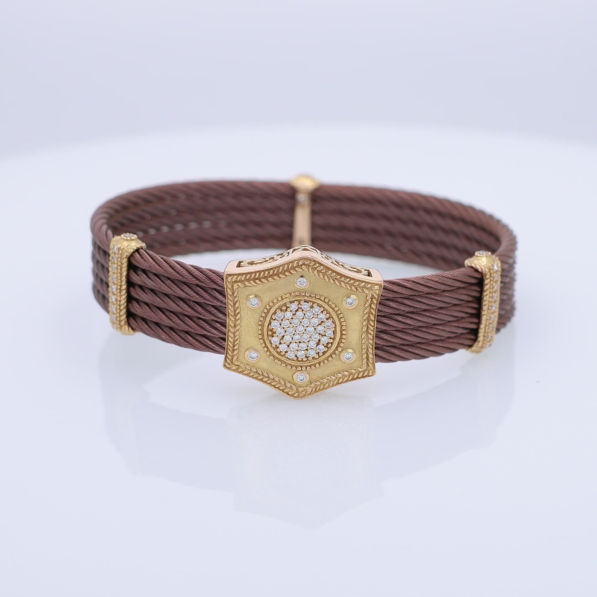 360 degree video of a brown braided bracelet with a gold clasp featuring a diamond-studded center on a white background