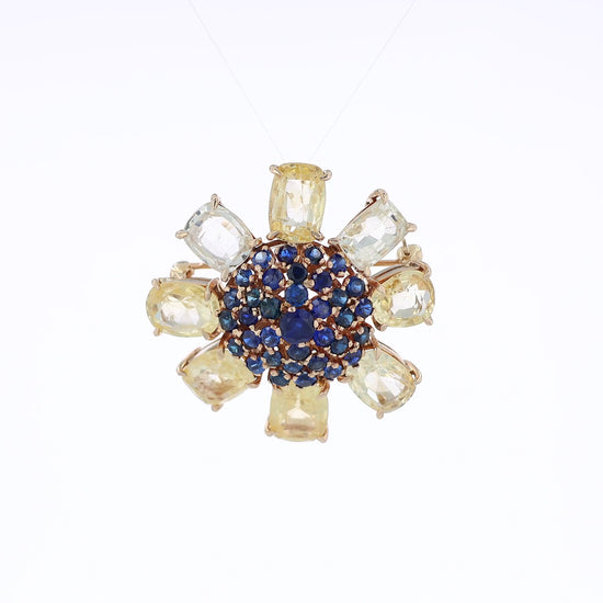 Yellow gold flower pin & pendant with outer yellow sapphires and inner blue sapphires on a white background