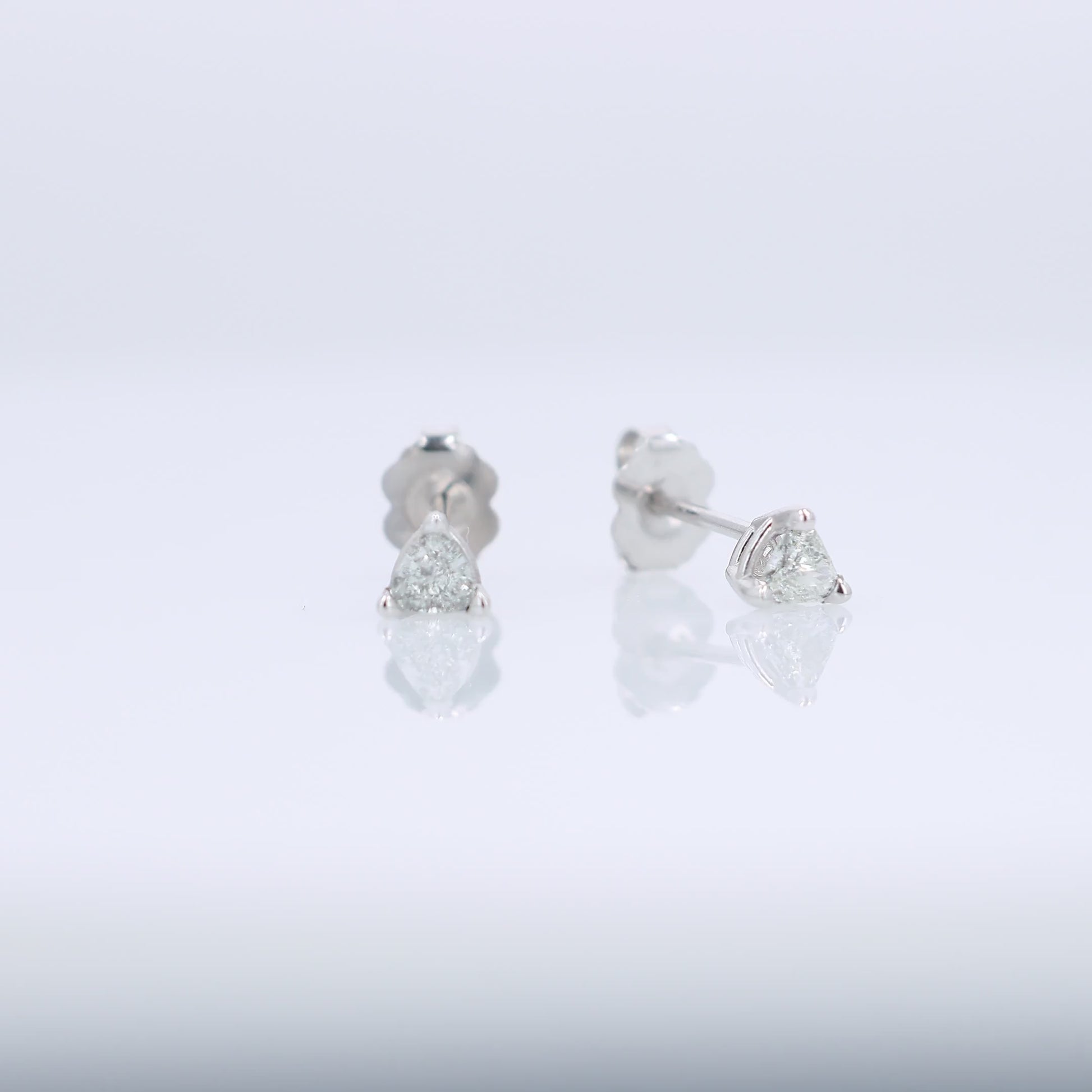 White gold trillion cut diamond stud earrings totaling 0.31 carats on a white background