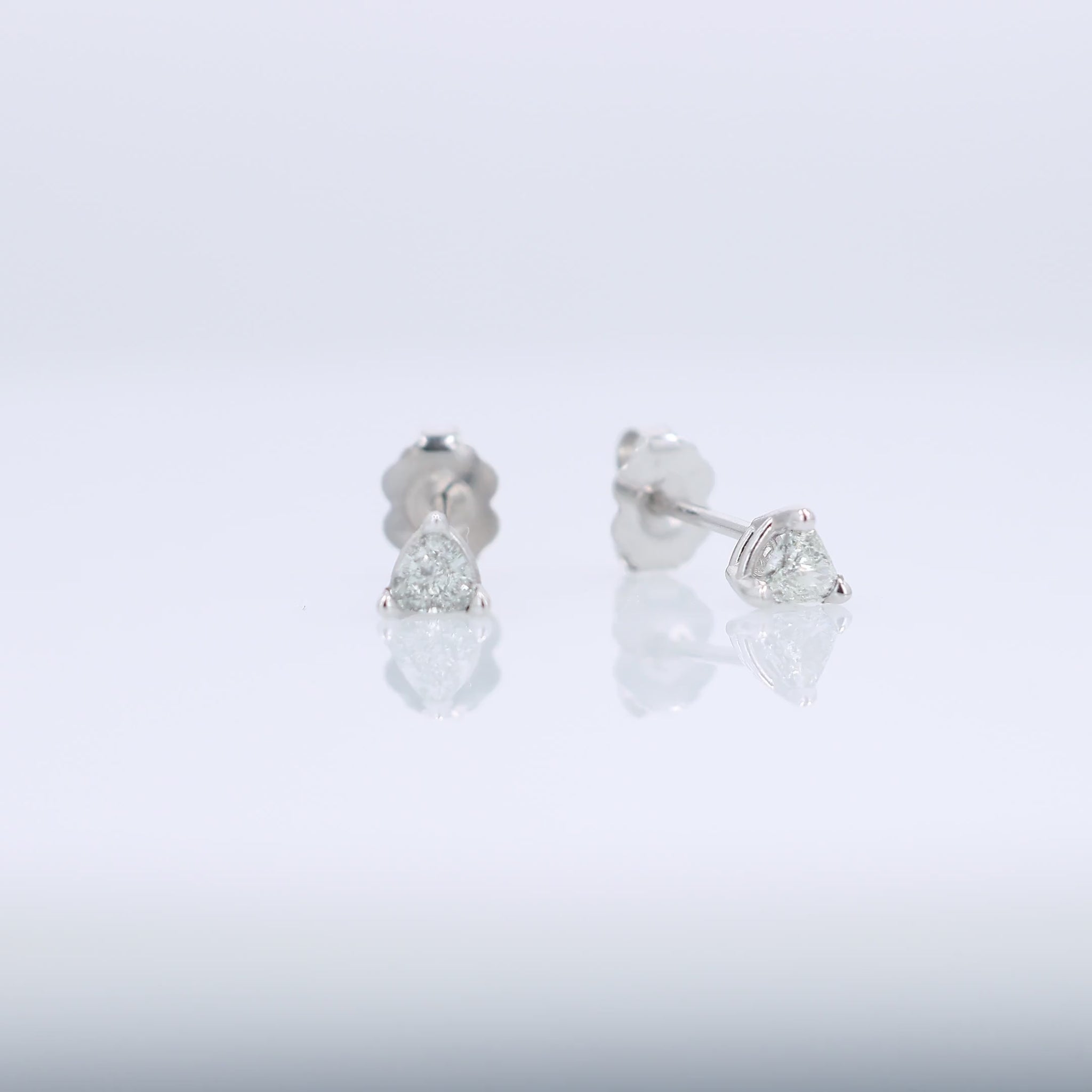 White gold trillion cut diamond stud earrings totaling 0.31 carats on a white background