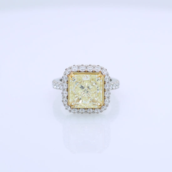 Platinum diamond halo ring with a yellow diamond center on a white background