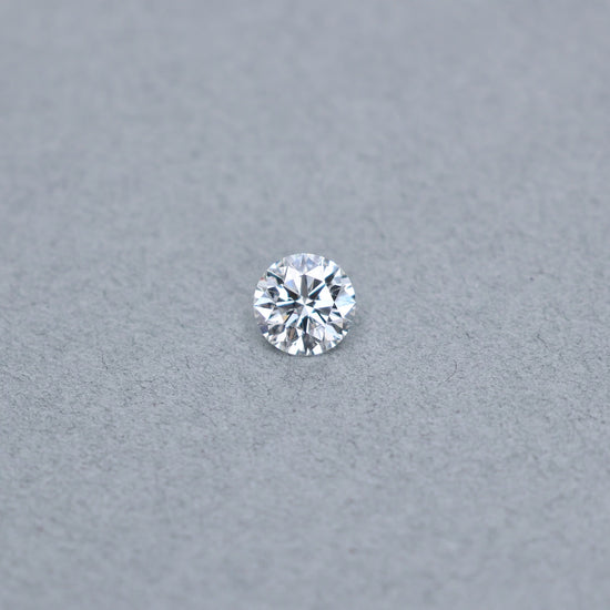 Round smyth triple excellent graded 1.55 carat diamond with F color and VS2 clarity on a grey background