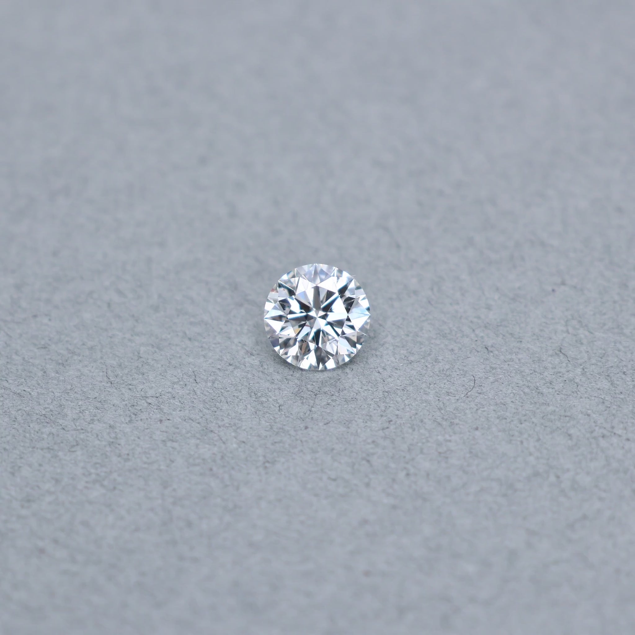 Round smyth triple excellent graded 1.55 carat diamond with F color and VS2 clarity on a grey background