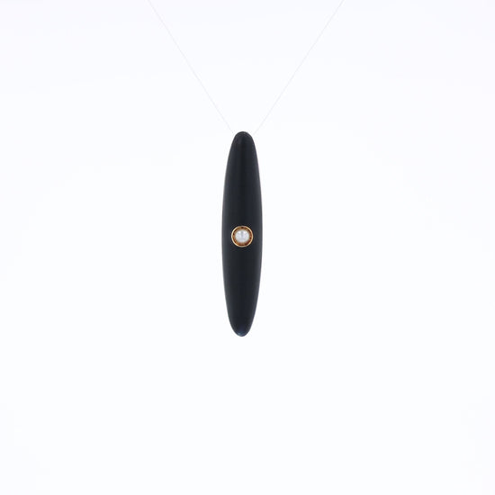 Yellow gold and black enamel pin with a pearl center on a white background