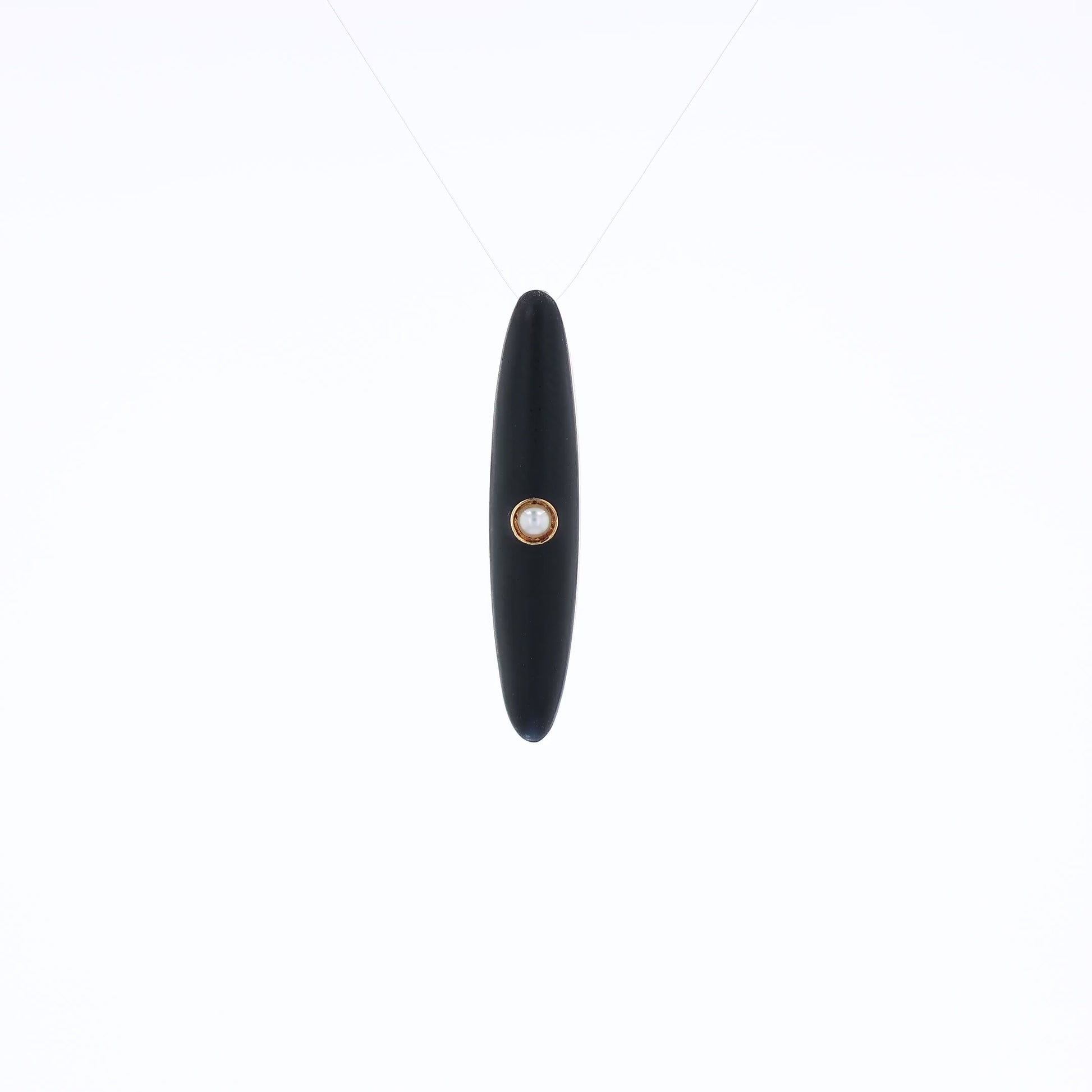 Yellow gold and black enamel pin with a pearl center on a white background
