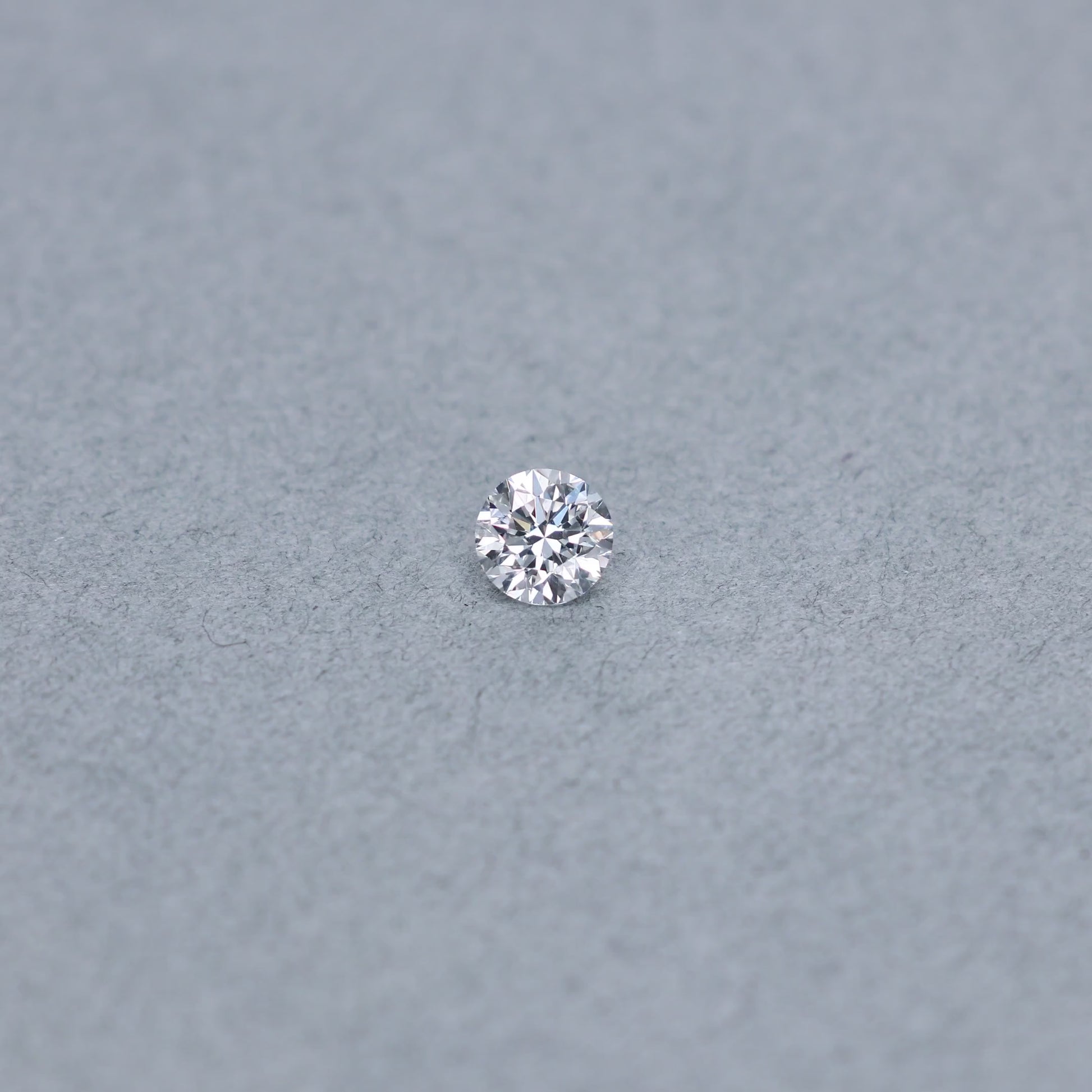 Round .70 carat GIA certified diamond graded DVS1 on a grey background