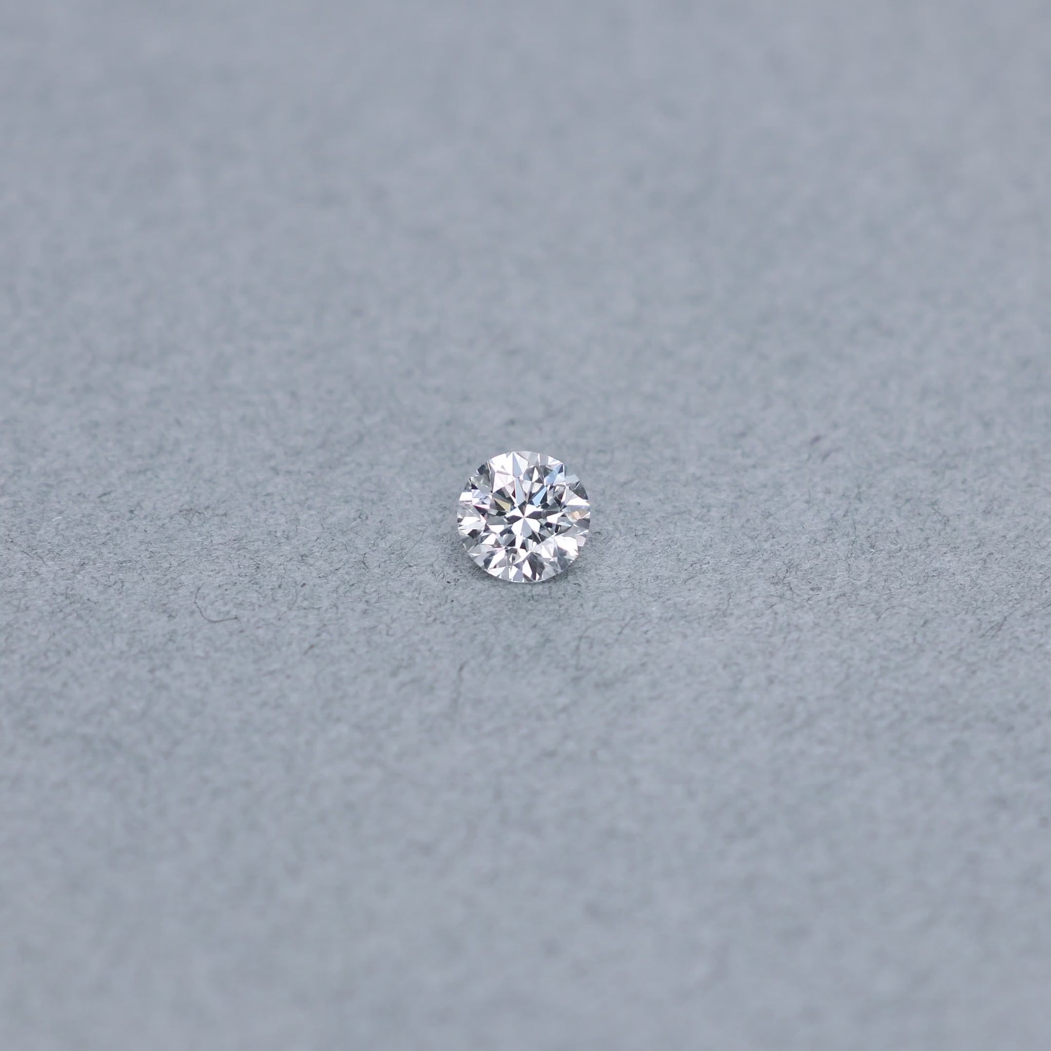 Round .70 carat GIA certified diamond graded DVS1 on a grey background