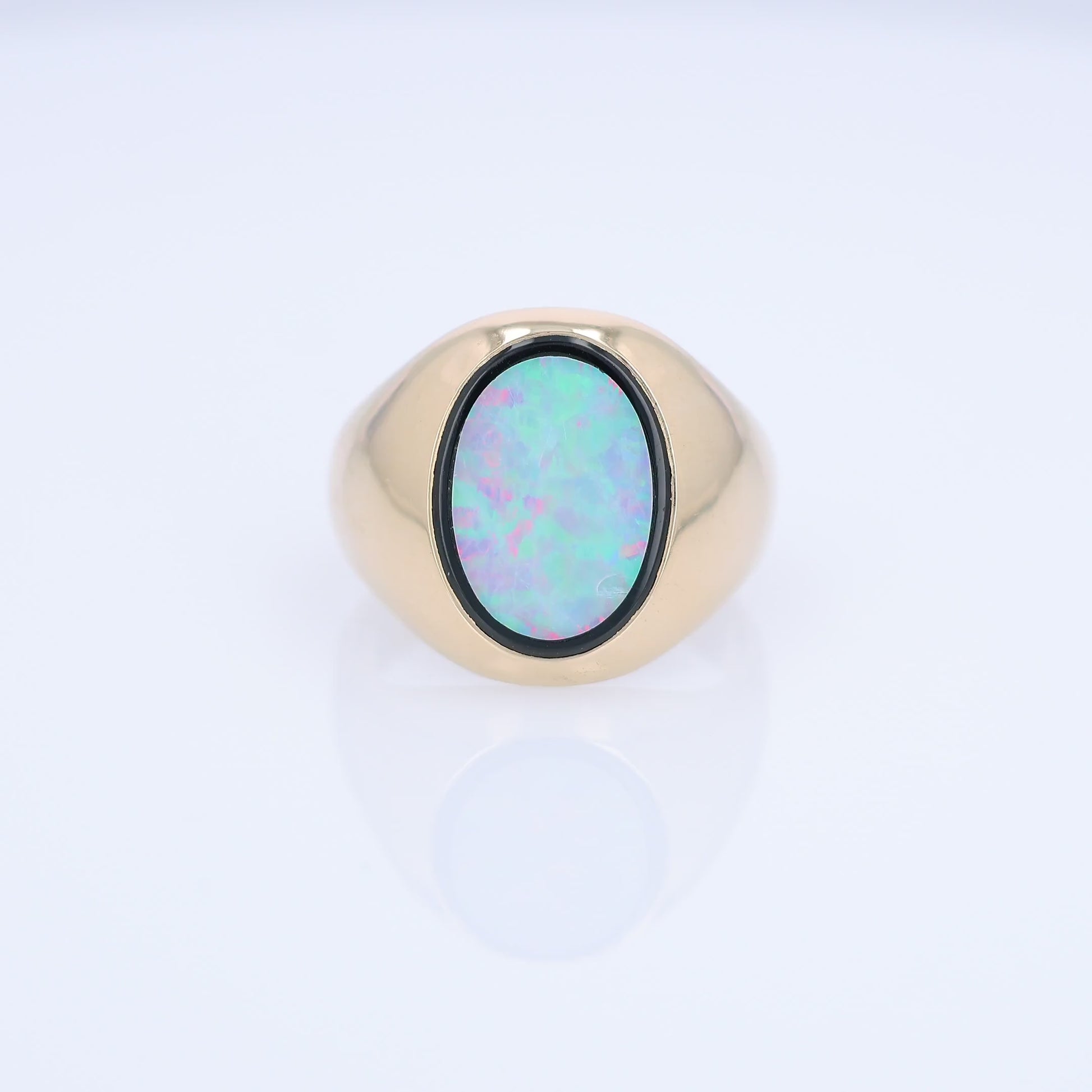 Yellow Gold oval opal doublet signet style ring on a white background
