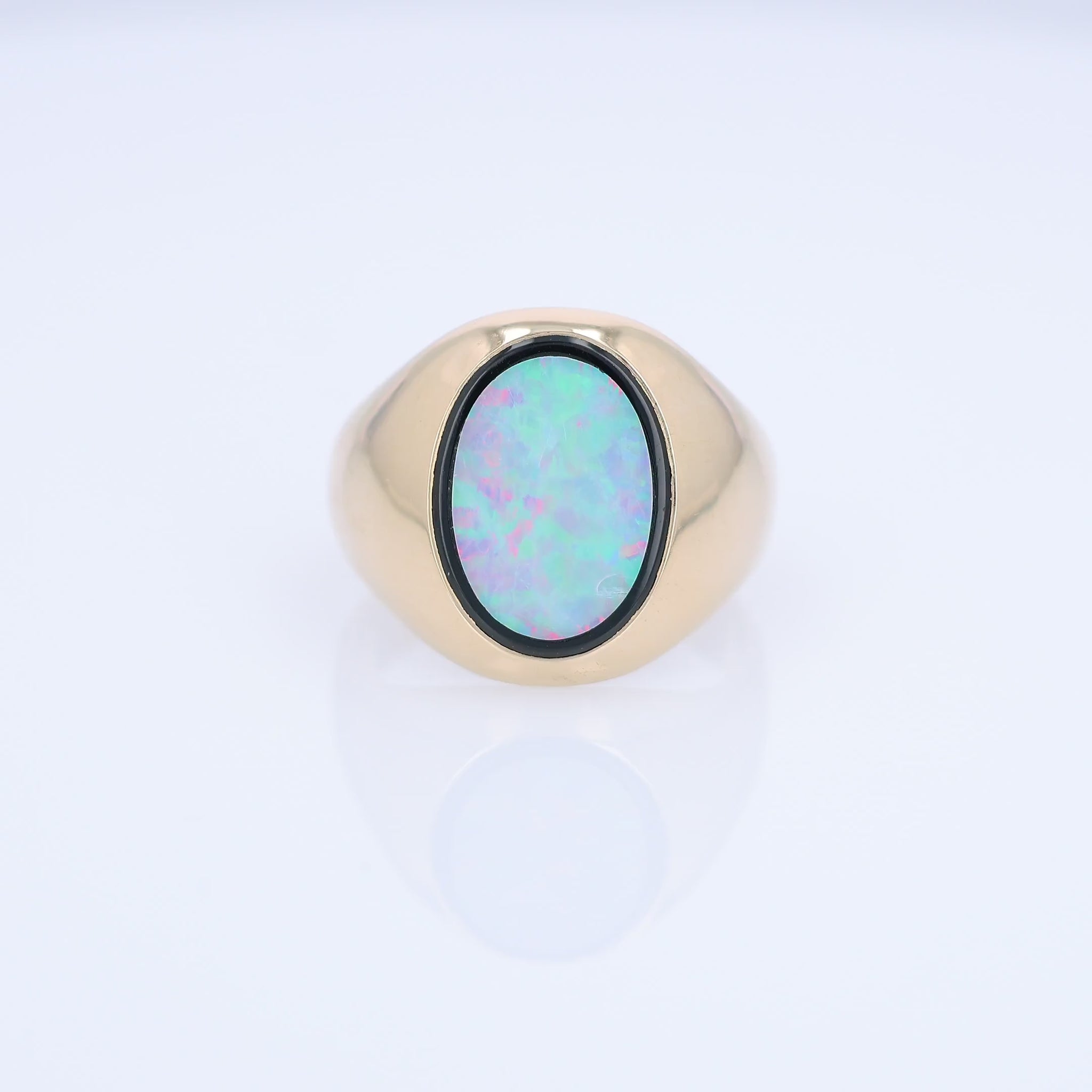 Yellow Gold oval opal doublet signet style ring on a white background