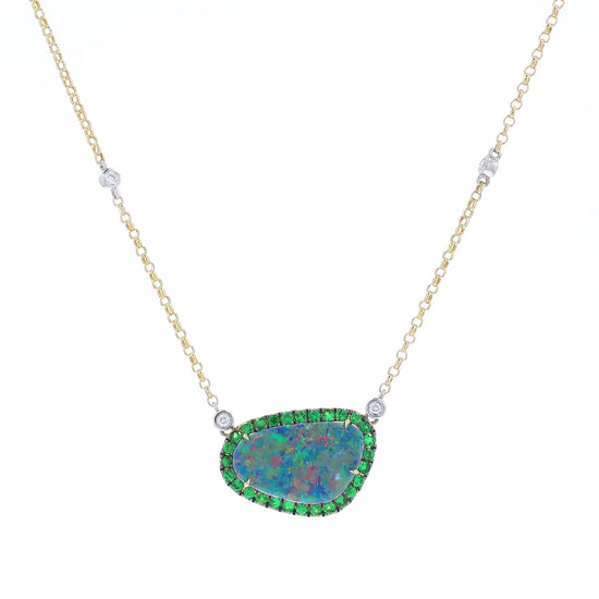 Yellow and white gold freeform opal, green tsavorite, and diamond halo pendant necklace on a white background