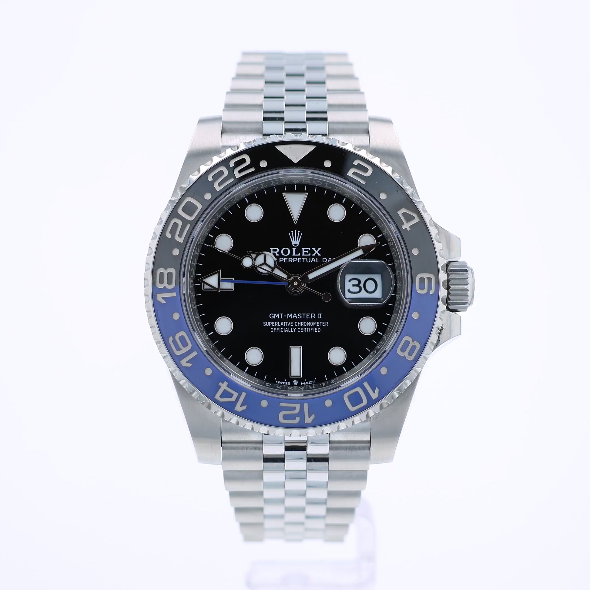 360 degree video of a Rolex watch with a black dial and blue and black bezel on a white background