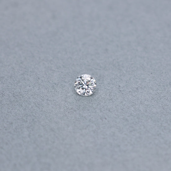 Round .81 carat diamond graded IVS2 on a grey background