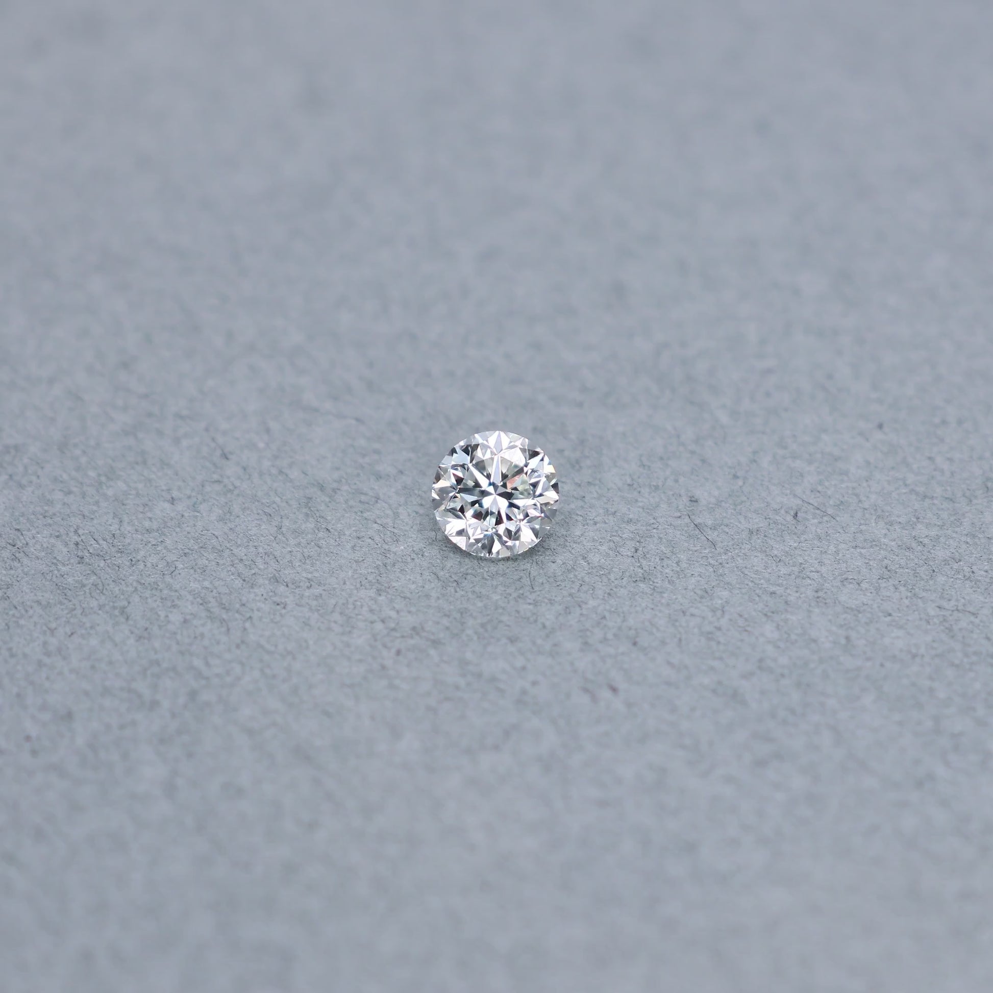 Round .81 carat diamond graded IVS2 on a grey background