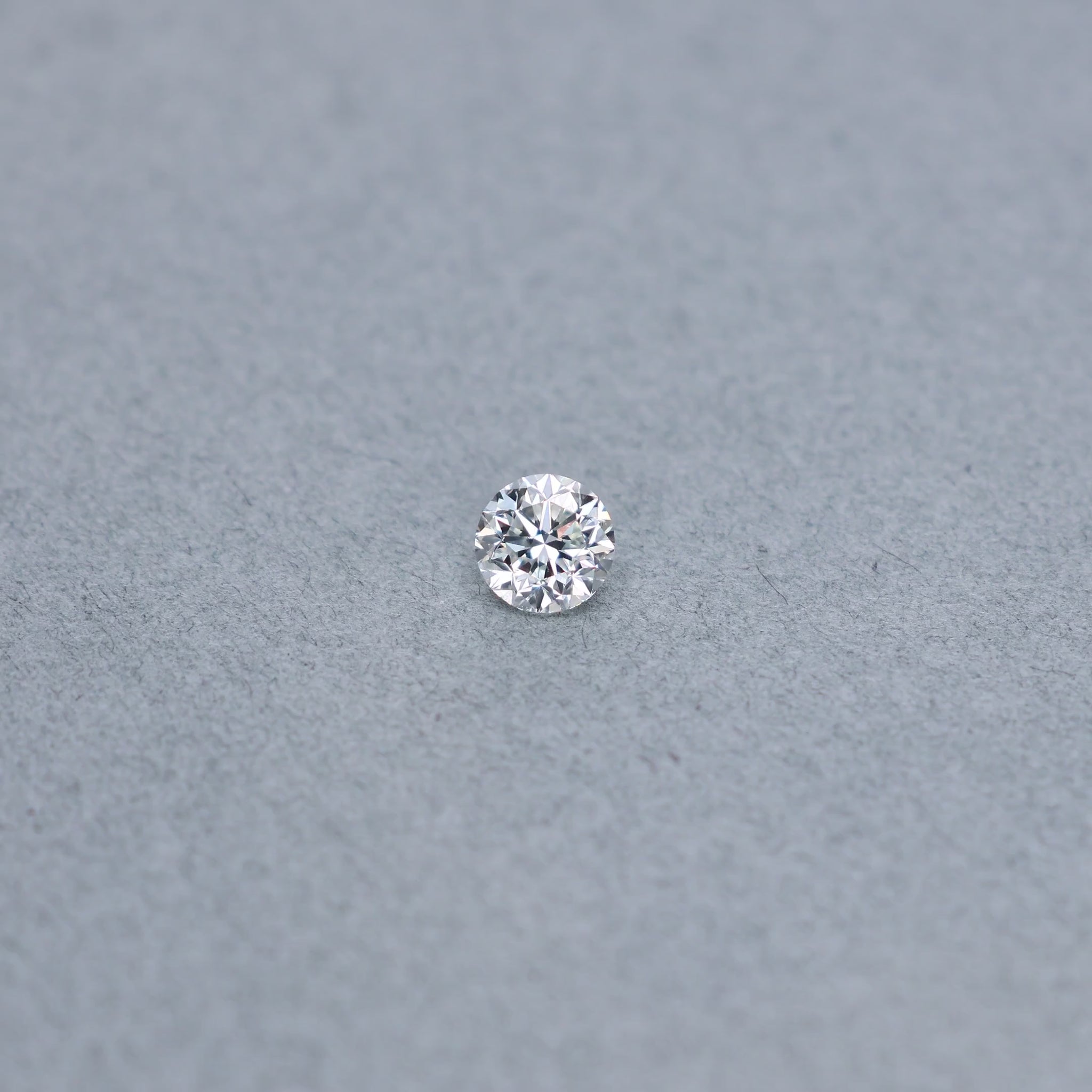 Round .81 carat diamond graded IVS2 on a grey background