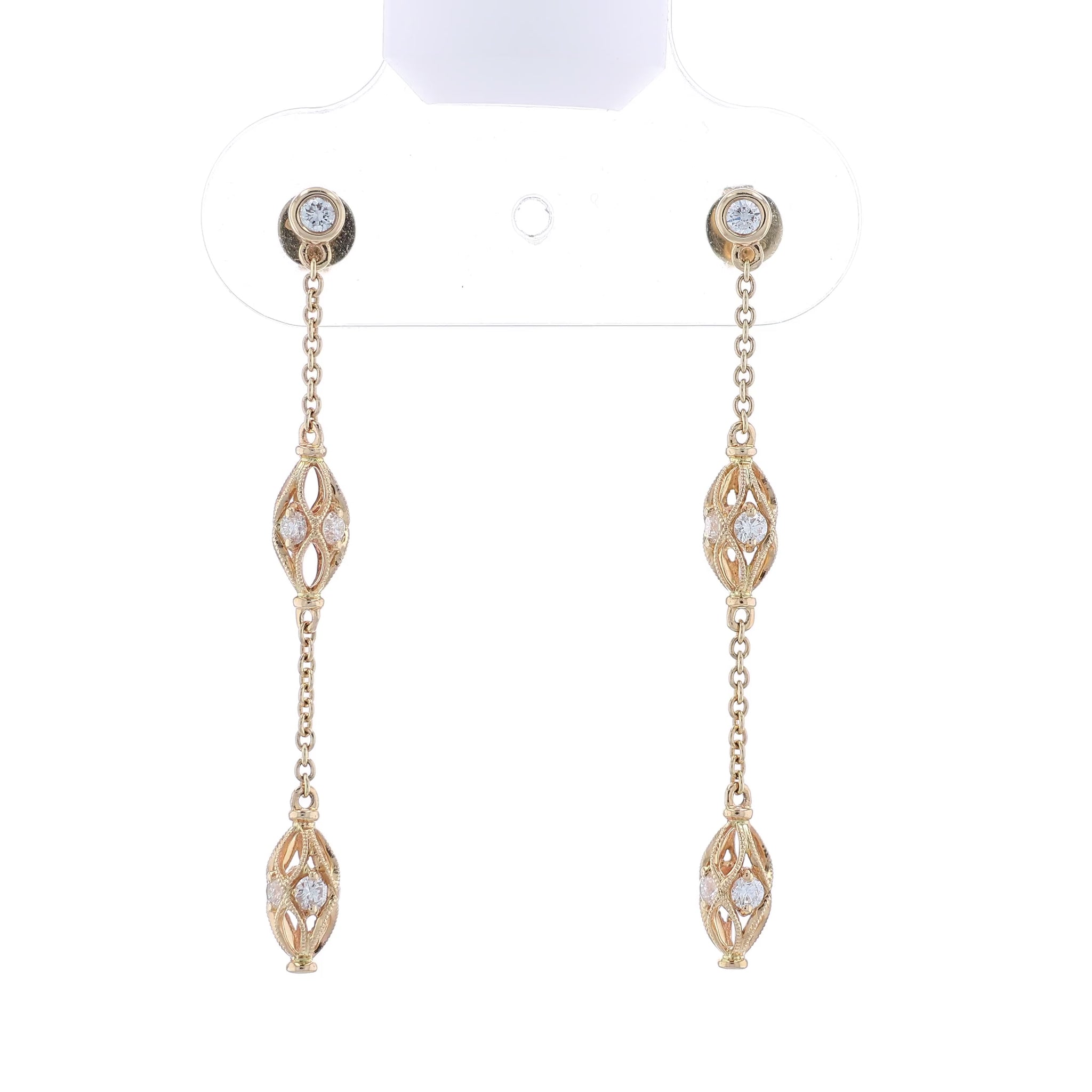 Gold dangle earrings with diamond accents on a white background