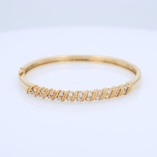Yellow gold rope border diamond bangle bracelet on a white background