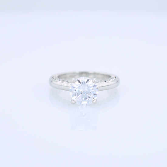 Platinum diamond engagement ring with diamond accents a round cubic zirconia center on a white background