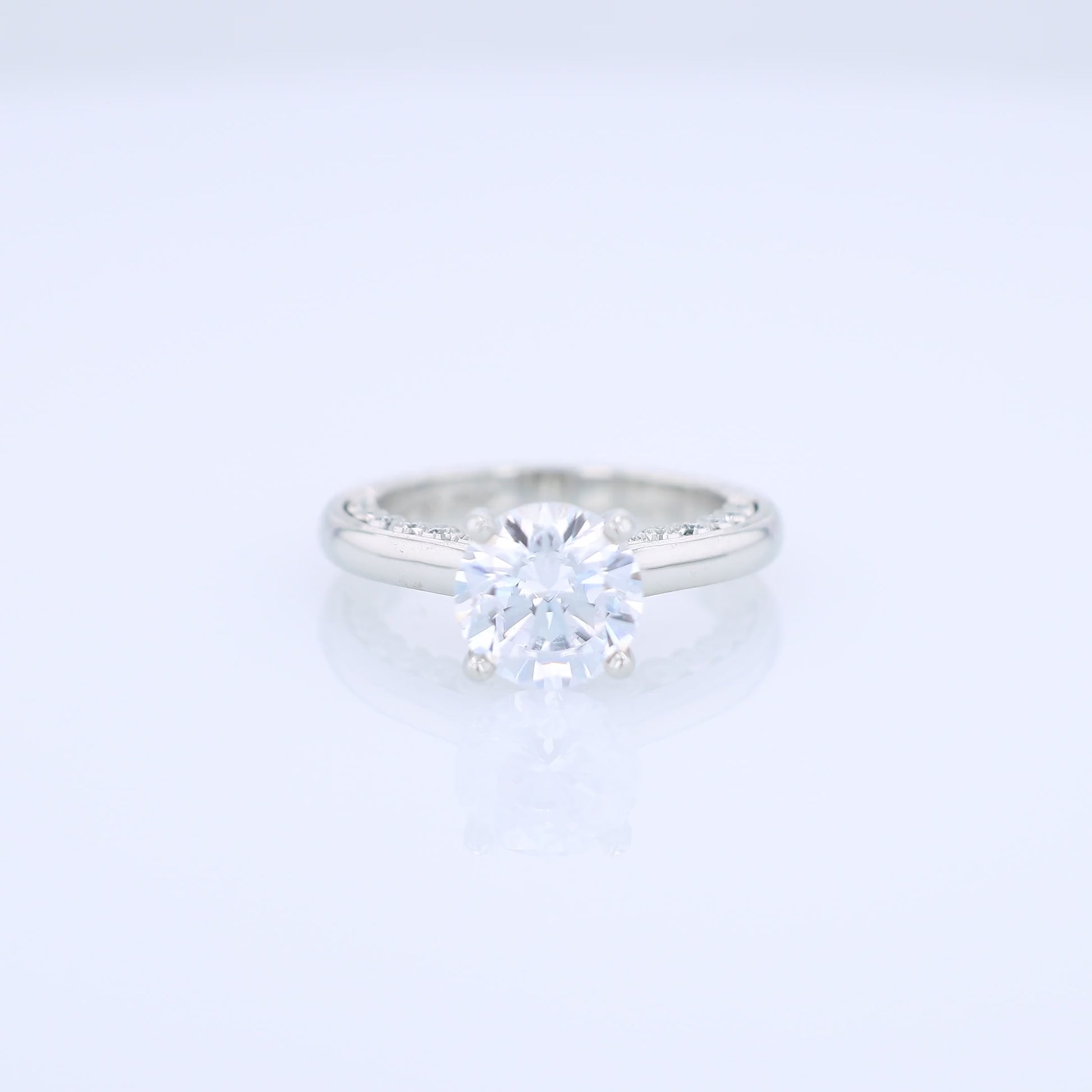 Platinum diamond engagement ring with diamond accents a round cubic zirconia center on a white background