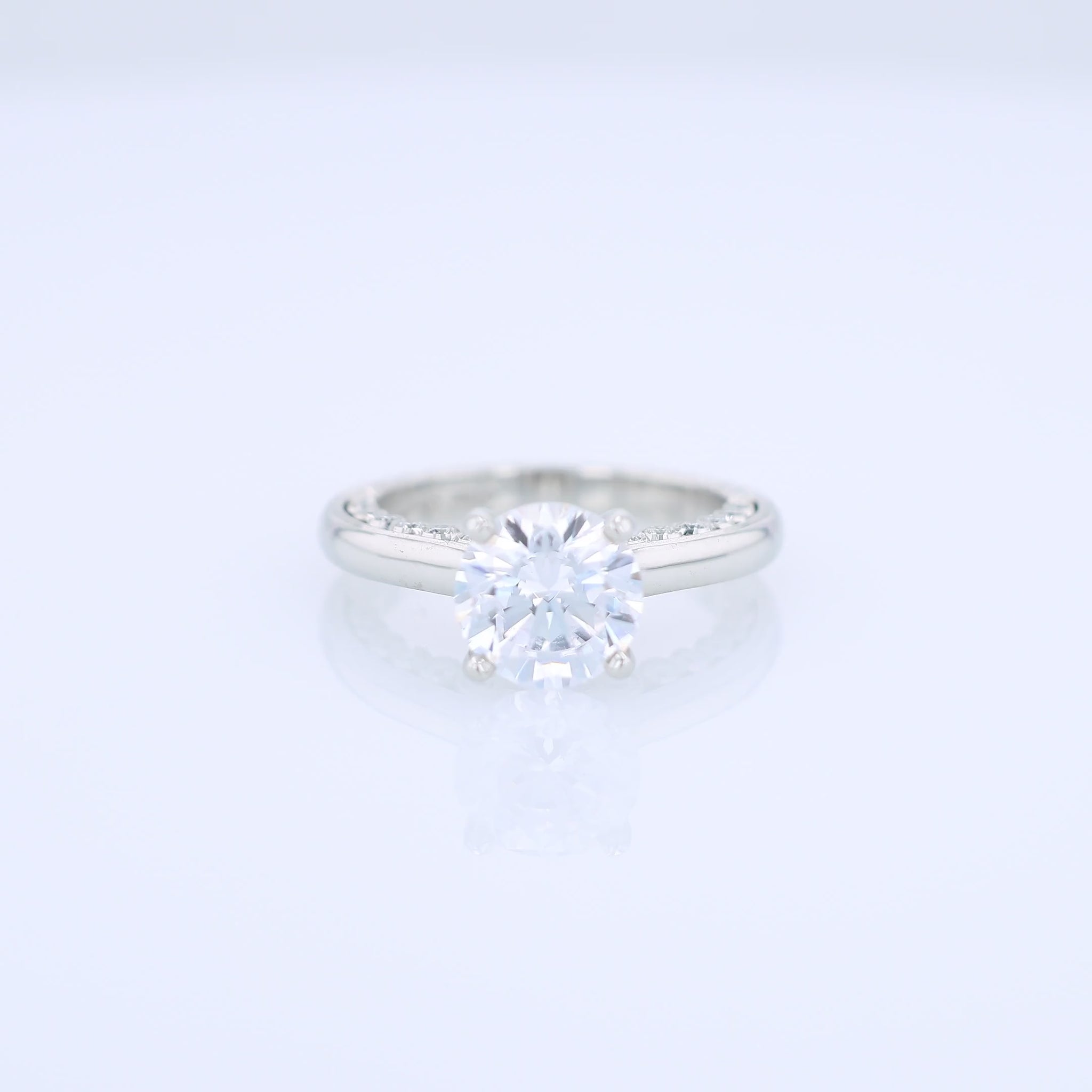 Platinum diamond engagement ring with diamond accents a round cubic zirconia center on a white background