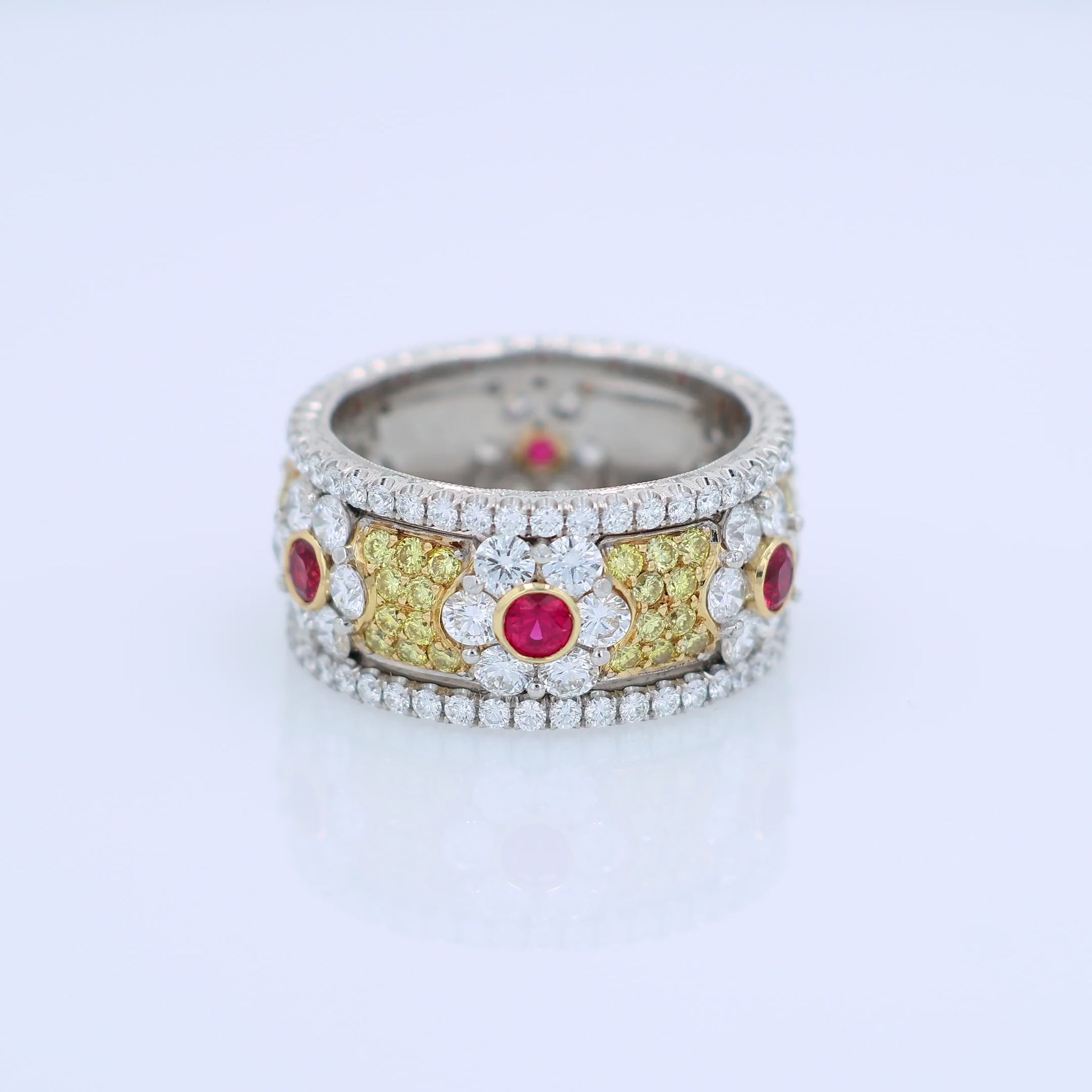 Platinum ring with ruby and white/yellow diamond accents on a white background