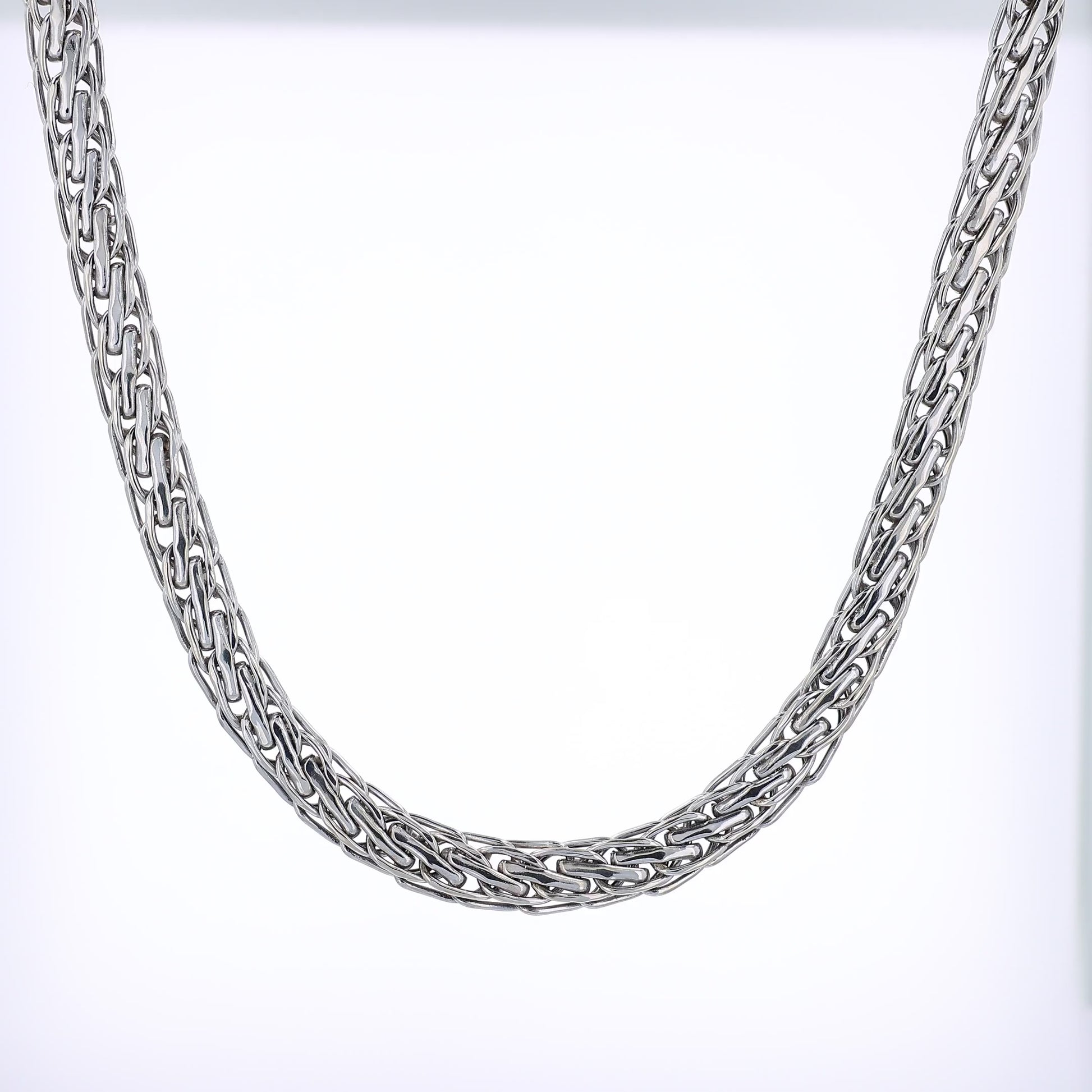 White gold braided intertwined link chain necklace on a white background