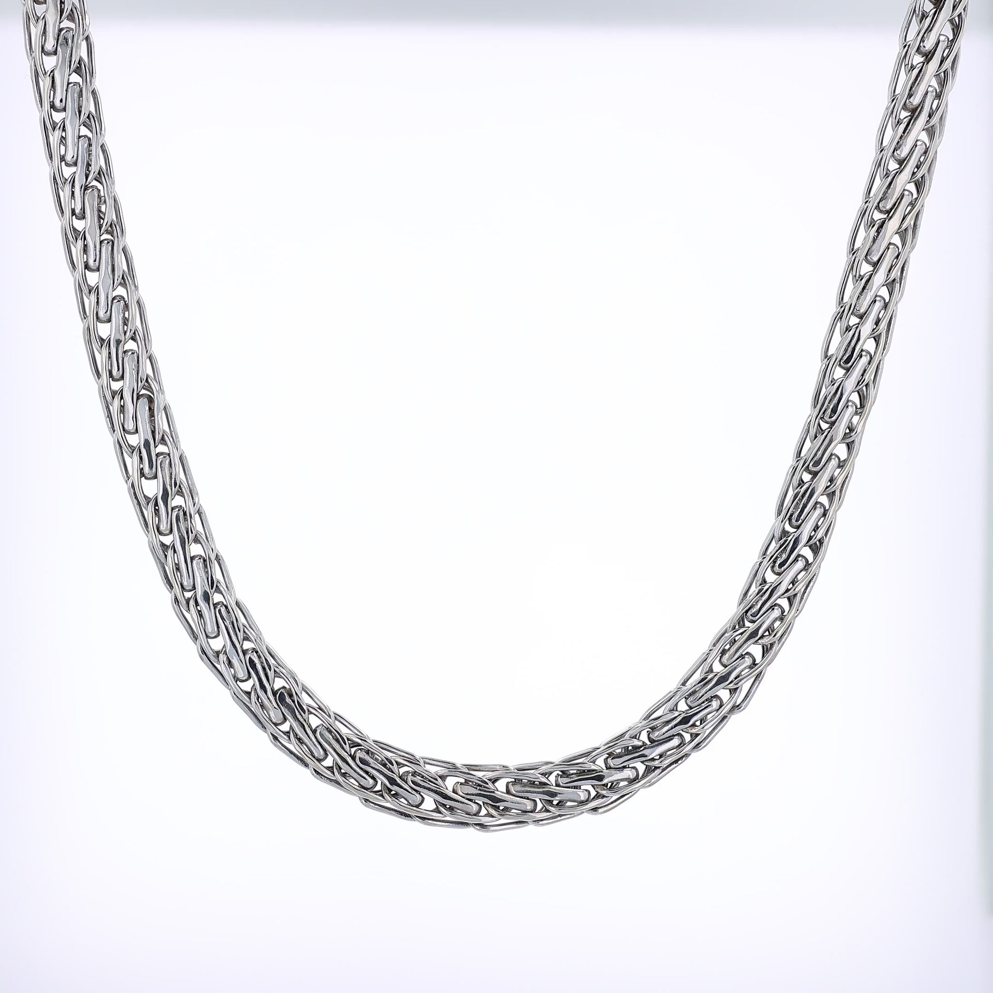 White gold braided intertwined link chain necklace on a white background