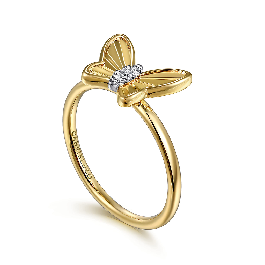 Gold butterfly ring with diamond accents on a white background