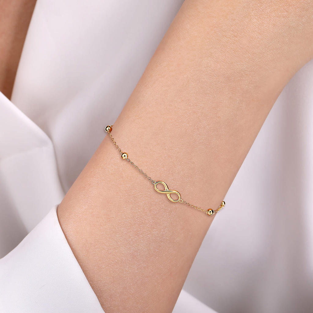 model wearing gold infinity symbol bracelet 