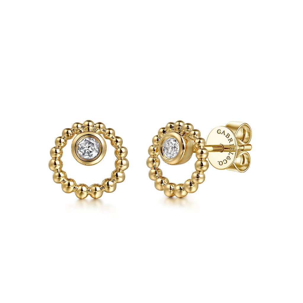 Gold earrings with circular design and embedded diamonds on a white background