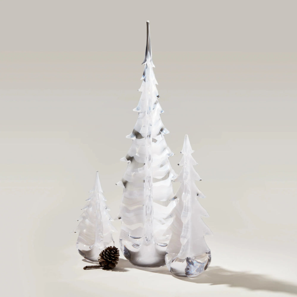 Set of three white Simon Pearce trees with a pine cone on a light gray background