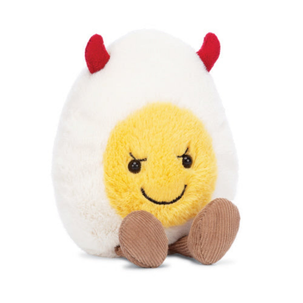Plush toy resembling a boiled egg with a face red devil horns on the top on a white background