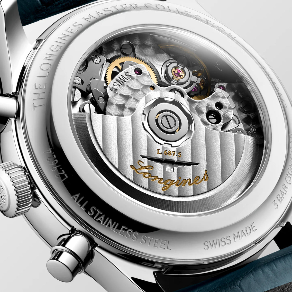 Close-up of the back of a Longines watch showing the transparent case back and visible mechanical movement, with engraved text including 'THE LONGINES MASTER COLLECTION' and 'Longines' in gold script.