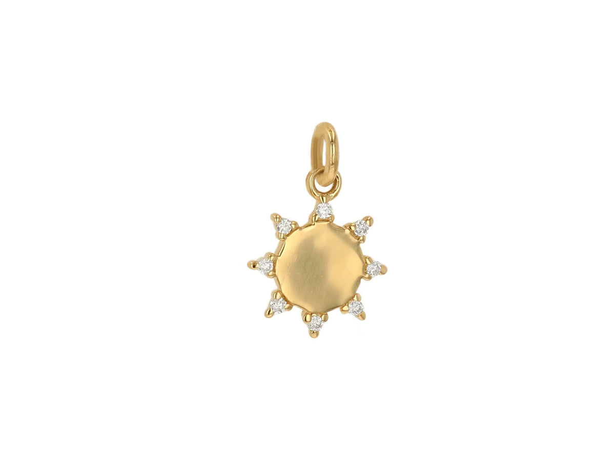 Gold sun-shaped pendant with diamond accents on a white background