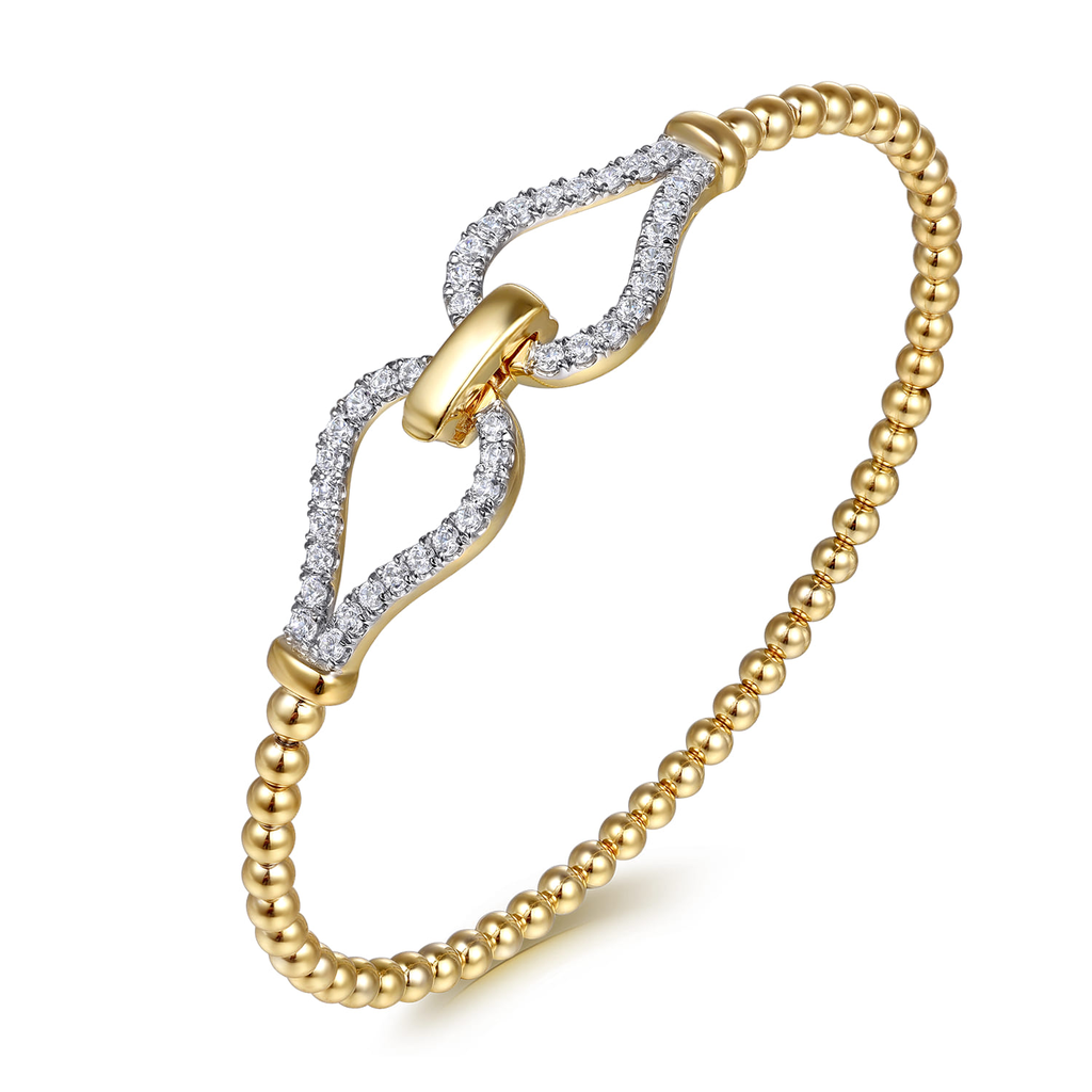 gold beaded stirrup bangle bracelet with clear stones on white background
