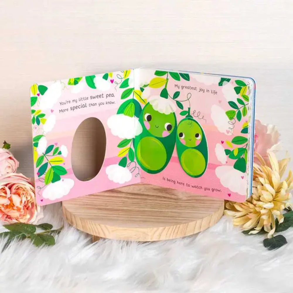Children's book with green characters on a pink background, surrounded by flowers.