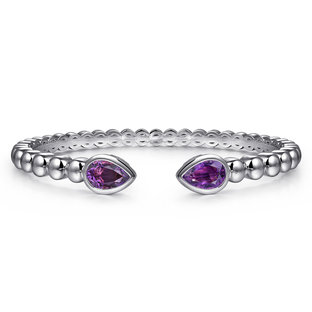 Silver ring with purple gemstones on a white background
