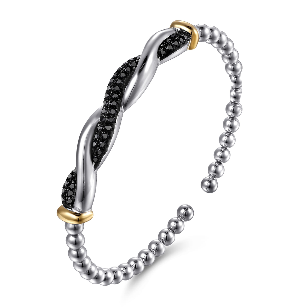 Silver bracelet with black stones and gold accents on a white background