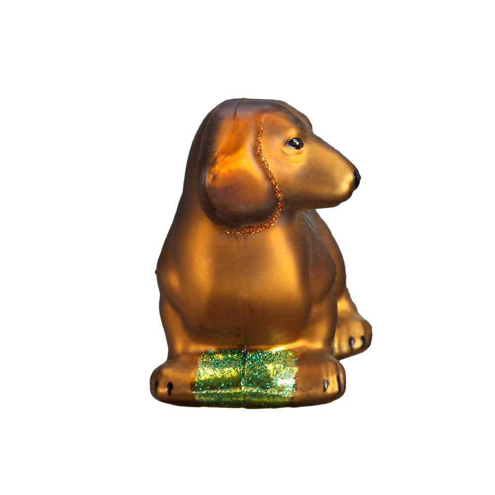 The front of a christmas ornament of a brown Dachshund on a white backround. 