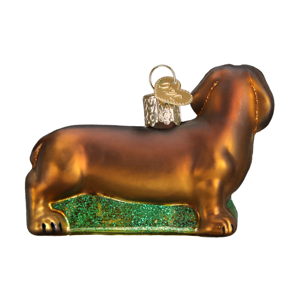 The back of a christmas ornament of a brown Dachshund on a white backround. 