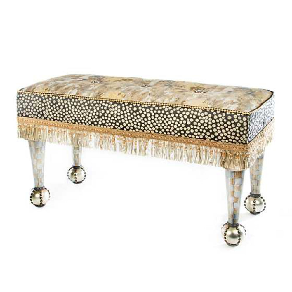 Decorative bench with embellished top and gold fringe on a white background