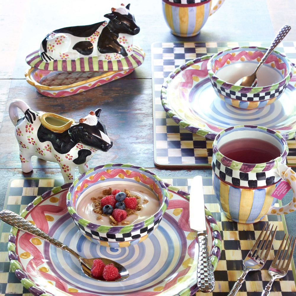 black and white checkered placemats on a table with other Mackenzie-Childs items