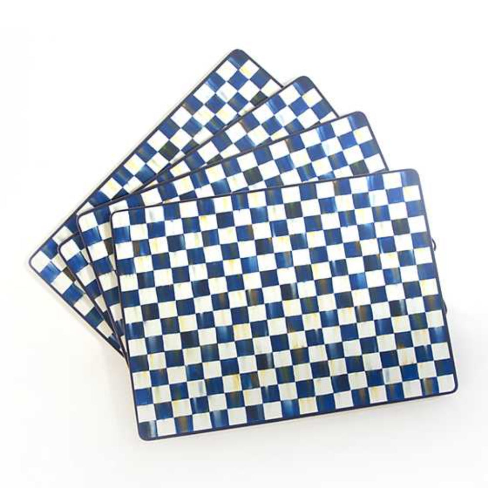 Set of four royal blue and white checkered placemats on a white background