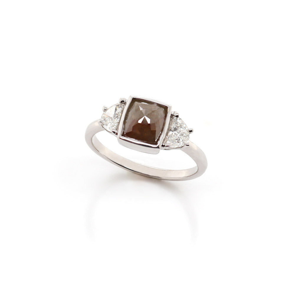 White gold ring with a salt & pepper diamond center with half moon cut diamond sides on a white background