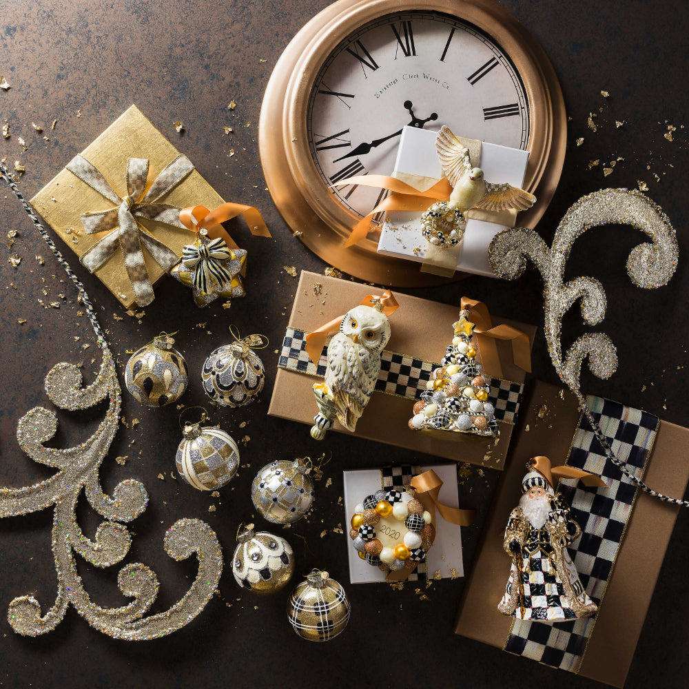 Life style photo of MacKenzie-Childs Golden Hour Glass Ball Ornaments - Set of 6 on a black backround with other holiday decor