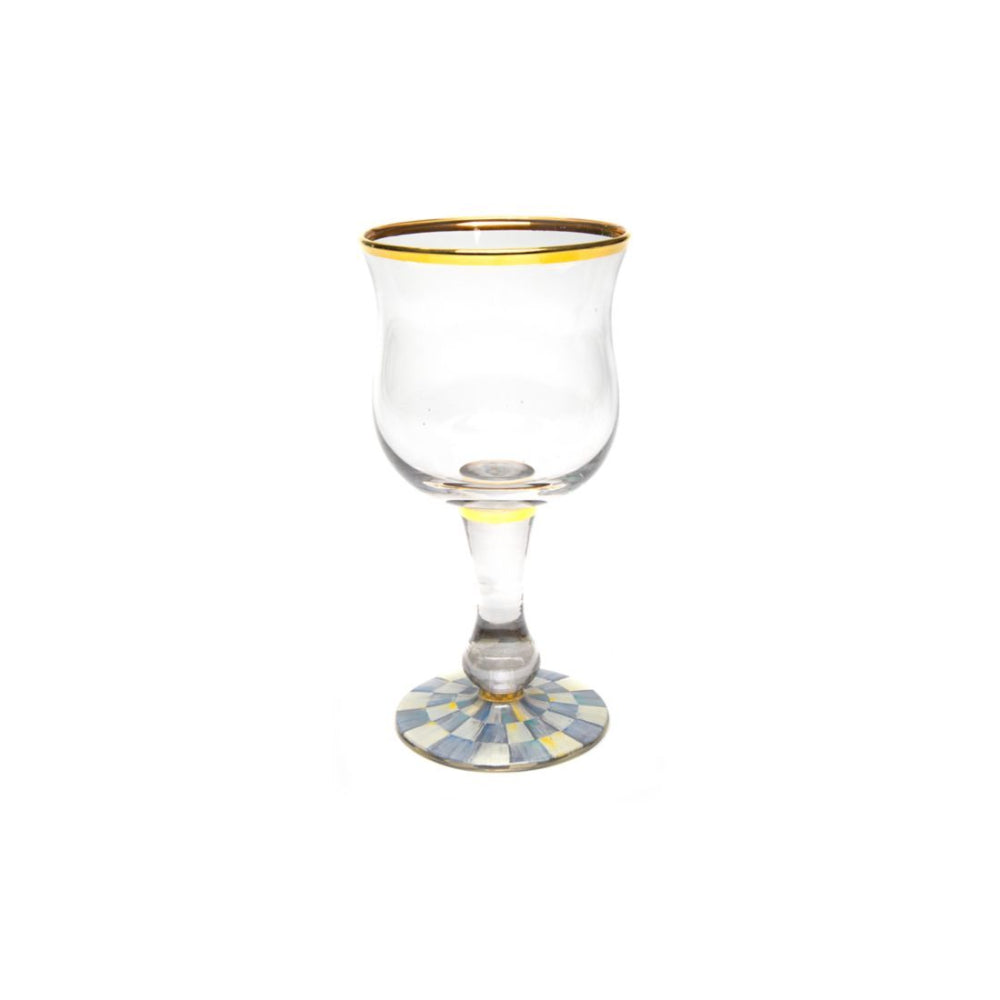 Clear glass with a gold rim with macKenzie-childs sterling check base on a white background