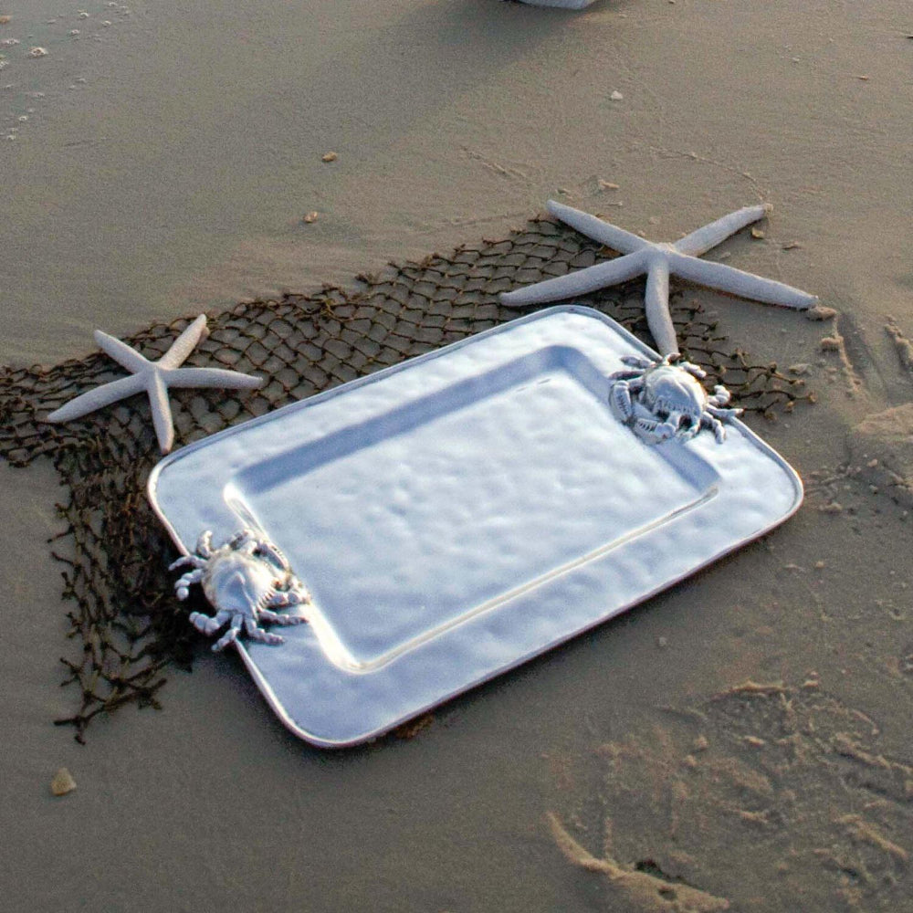 Silver tray with crab handles on a a beach with a net and star fish.