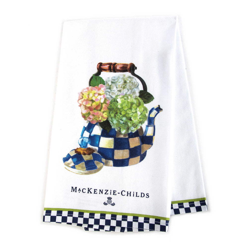White towel with a blue floral teapot design and 'Mackenzie-Childs' branding