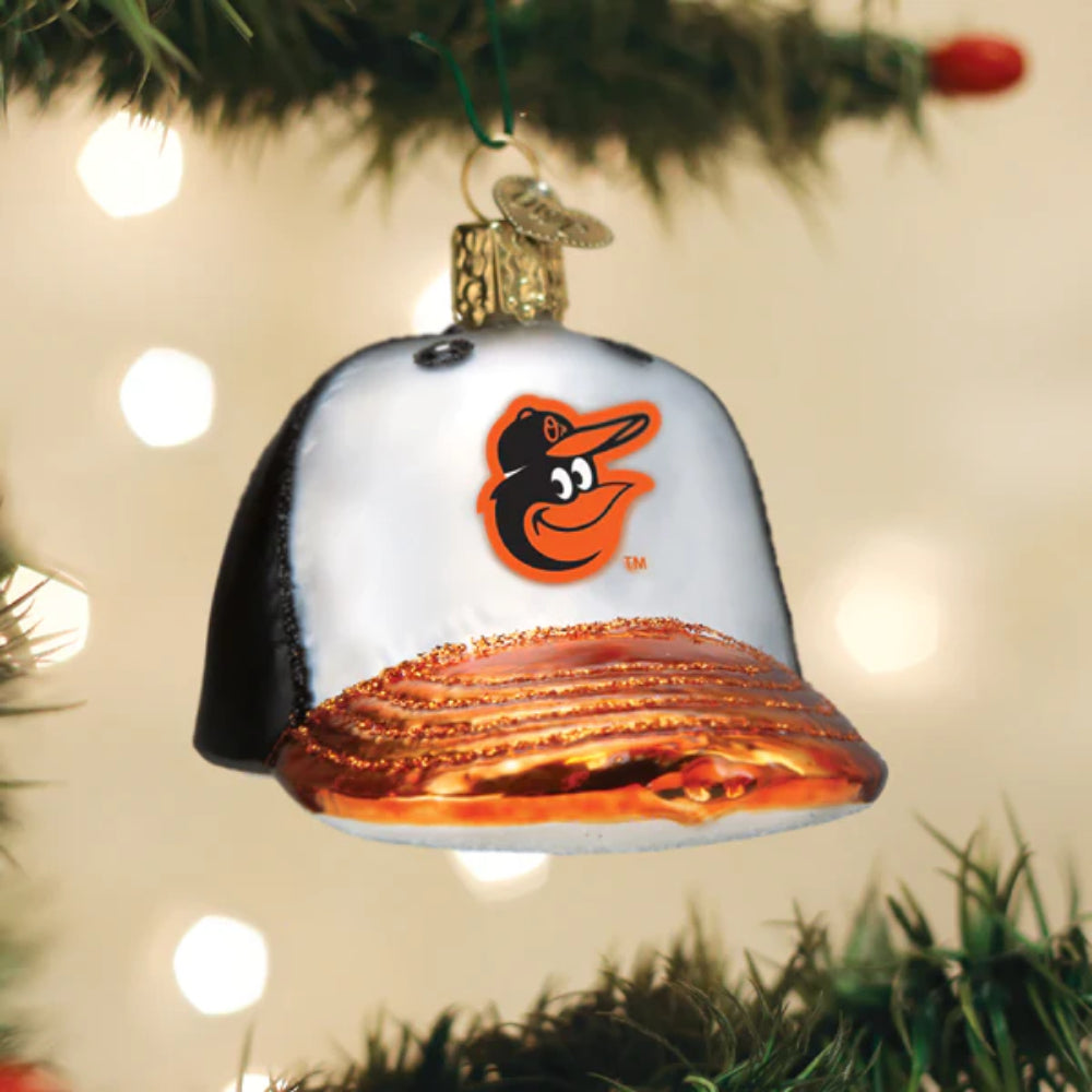 A close up of a glass ball cap ornament with a Orioles logo on a tree.