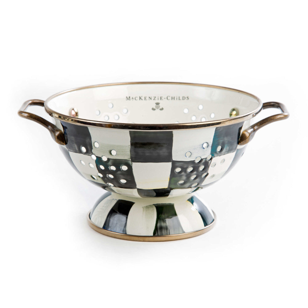 Decorative colander with checkered black & white pattern and gold accents on a white background.